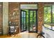 Balcony entrance next to exposed brick wall features a work station and overlooks lush greenery at 3235 Roswell Ne Rd # 505, Atlanta, GA 30305