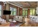 Bright living area featuring exposed brick, hardwood floors, and access to the outdoor balcony at 3235 Roswell Ne Rd # 505, Atlanta, GA 30305