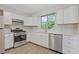Modern kitchen features stainless steel appliances, bright white cabinetry, and hardwood floors at 2426 Corner Shoals Dr, Decatur, GA 30034