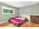 This bedroom features a comfortable bed, wooden floors, a window view, and a wooden cabinet for storage at 281 Lakeshore Ne Dr, Marietta, GA 30067