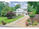 Charming two-story home with a well-maintained lawn, landscaped yard, and a long driveway leading to a garage at 281 Lakeshore Ne Dr, Marietta, GA 30067