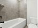 Bathroom featuring a white bathtub with gray tile surround at 5120 Kongoni Ct, Cumming, GA 30041