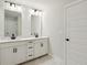 Modern bathroom featuring double sinks with black hardware, white cabinetry and marble floors at 5120 Kongoni Ct, Cumming, GA 30041