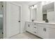Bright bathroom featuring double sinks with black hardware, white cabinetry and marble floors at 5120 Kongoni Ct, Cumming, GA 30041