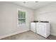 Functional laundry room with tile flooring, window, and modern washer and dryer at 5120 Kongoni Ct, Cumming, GA 30041