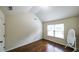 Bedroom featuring hardwood floors, bright window, and an elegant full-length mirror for a sophisticated touch at 8744 Hamil Ct, Douglasville, GA 30135