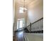 This foyer features a beautiful chandelier, wainscoting, hardwood floors, and a staircase with iron spindles at 8744 Hamil Ct, Douglasville, GA 30135