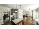 Open concept kitchen featuring island, granite counters, dark cabinets, and hardwood floors, leading into living area at 8744 Hamil Ct, Douglasville, GA 30135