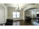This living room features hardwood floors, an elegant chandelier, wainscoting, and arched entryways at 8744 Hamil Ct, Douglasville, GA 30135