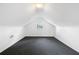 A spacious attic room with neutral paint, gray carpet, and a window allowing natural light at 1844 Stanton St, Decatur, GA 30032