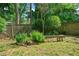A tranquil backyard retreat features a wooden bench surrounded by lush greenery and a wooden fence at 1844 Stanton St, Decatur, GA 30032