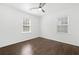 This bedroom features sleek hardwood floors, neutral-toned walls, a modern ceiling fan, and natural light from two windows at 1844 Stanton St, Decatur, GA 30032