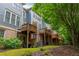 A spacious backyard with wooden decks, green lawn, trees, plants, and the back of townhouses at 2025 Eagle Rdg, Roswell, GA 30076