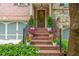 Inviting front porch with brick steps, black iron railings, and potted plants, leading to the front door at 2025 Eagle Rdg, Roswell, GA 30076