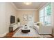 Bright living room with a sleek sofa, modern decor, and a large window at 2025 Eagle Rdg, Roswell, GA 30076