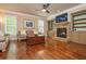 Cozy living room with hardwood floors, stone fireplace, built-in shelves, and ample natural light at 2025 Eagle Rdg, Roswell, GA 30076
