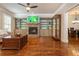 Spacious living room with hardwood floors, stone fireplace, built-in shelving, and adjacent dining area at 2025 Eagle Rdg, Roswell, GA 30076