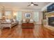 Bright and airy living room featuring hardwood floors, a stone fireplace, and plantation shutters at 2025 Eagle Rdg, Roswell, GA 30076