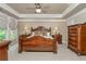 Elegant main bedroom with tray ceiling, ceiling fan, and wood furniture at 2025 Eagle Rdg, Roswell, GA 30076