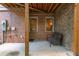 A shaded patio with red brick walls, concrete floors, wooden supports and wicker furniture at 2025 Eagle Rdg, Roswell, GA 30076