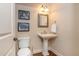 Charming powder room with pedestal sink, decorative mirror, and hardwood floors at 2025 Eagle Rdg, Roswell, GA 30076