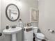 Charming powder room with pedestal sink, decorative mirror, and stylish fixtures at 3386 Vintage Se Cir # 8, Smyrna, GA 30080