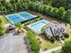 Aerial view showcases the community pool, tennis courts, and clubhouse surrounded by lush greenery at 4115 Williams Point Dr, Cumming, GA 30028