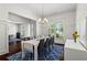 Bright dining room with modern table seating for eight, view into living room and natural light at 4115 Williams Point Dr, Cumming, GA 30028