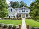 Inviting two-story home with lush landscaping, a manicured lawn, and a white picket fence at 4115 Williams Point Dr, Cumming, GA 30028