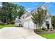 Beautiful home showcasing a three-car garage, lush landscaping, and well-maintained driveway at 4115 Williams Point Dr, Cumming, GA 30028