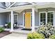 Charming home entrance featuring a bright yellow door, rocking chairs, and meticulously maintained landscaping at 4115 Williams Point Dr, Cumming, GA 30028