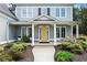 Inviting front porch with a yellow door, white columns, lush landscaping, and a welcoming pathway at 4115 Williams Point Dr, Cumming, GA 30028