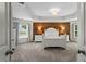 Elegant main bedroom showcasing a wood accent wall, tray ceilings, and a seating area at 4115 Williams Point Dr, Cumming, GA 30028