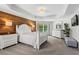 This main bedroom features stylish decor, a wood accent wall, and ample natural light at 4115 Williams Point Dr, Cumming, GA 30028