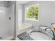 Bathroom features double sink, shower, and bathtub with large window view at 4914 Watson Mill Ct, Loganville, GA 30052