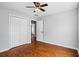 Cozy bedroom featuring a ceiling fan, wood-look flooring, and a convenient closet for storage at 4914 Watson Mill Ct, Loganville, GA 30052