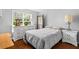 Bedroom features a large window, wood-look flooring, and is decorated with a nightstand and dresser at 4914 Watson Mill Ct, Loganville, GA 30052