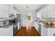 Bright kitchen features white cabinets, stainless appliances, granite countertops, and hardwood floors at 4914 Watson Mill Ct, Loganville, GA 30052