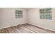 Bedroom featuring wood-look floors, neutral walls, and natural light from two windows at 1034 Sandy Ridge Rd, Mcdonough, GA 30252