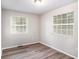 Bright bedroom featuring wood-look floors, neutral walls, and natural light from two windows at 1034 Sandy Ridge Rd, Mcdonough, GA 30252