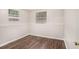 Bedroom featuring wood-look floors, neutral walls, and natural light from two windows at 1034 Sandy Ridge Rd, Mcdonough, GA 30252