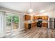Open kitchen with stainless steel refrigerator, black appliances, wooden cabinets, and sliding door to deck at 1034 Sandy Ridge Rd, Mcdonough, GA 30252
