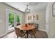 Dining area with wood table and access to the outdoor patio via glass panel doors at 6375 Eidson Dr, Cumming, GA 30041