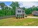 Well-maintained gray two-story home with a spacious lawn, complemented by mature trees and a wooden fence at 6375 Eidson Dr, Cumming, GA 30041