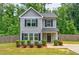 Charming two-story home with gray siding, black shutters, and a well-maintained front yard with landscaping at 6375 Eidson Dr, Cumming, GA 30041