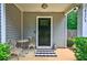 Inviting front porch featuring a small table and chairs, and a decorative black and white rug at 6375 Eidson Dr, Cumming, GA 30041