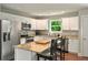 Bright kitchen features stainless steel appliances, granite countertops, and white cabinetry at 6375 Eidson Dr, Cumming, GA 30041