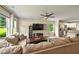 Bright living room with a large sectional sofa, a ceiling fan, and natural light from the windows at 6375 Eidson Dr, Cumming, GA 30041
