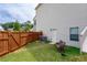 View of a well-maintained backyard featuring a bench, fence, grass and access to the home at 6585 Canyon Cv, Cumming, GA 30028
