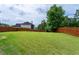 Large backyard featuring lawn, wood fence, and mature trees at 6585 Canyon Cv, Cumming, GA 30028